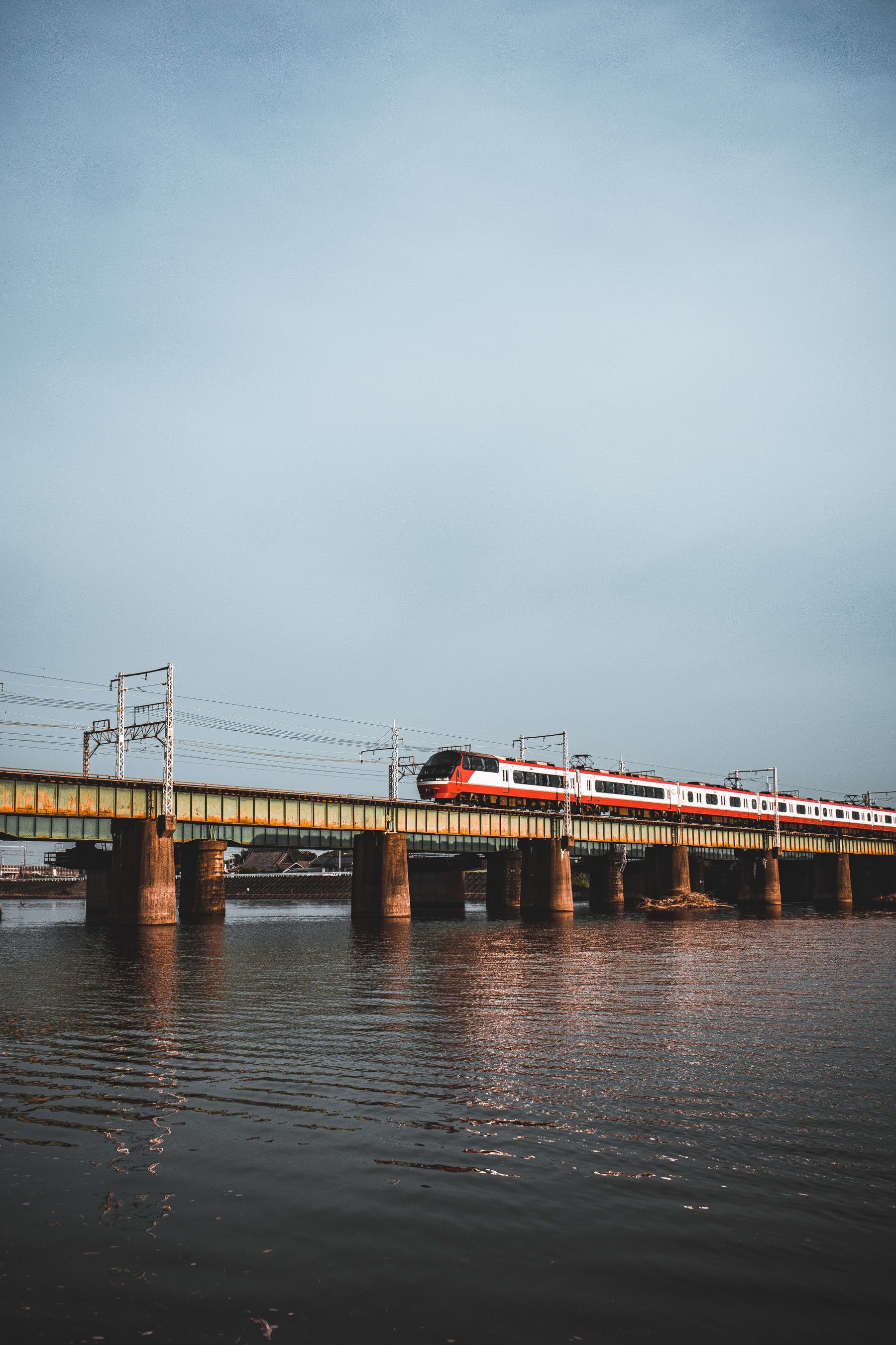 A passenger train crossing a railway bridge in Japan