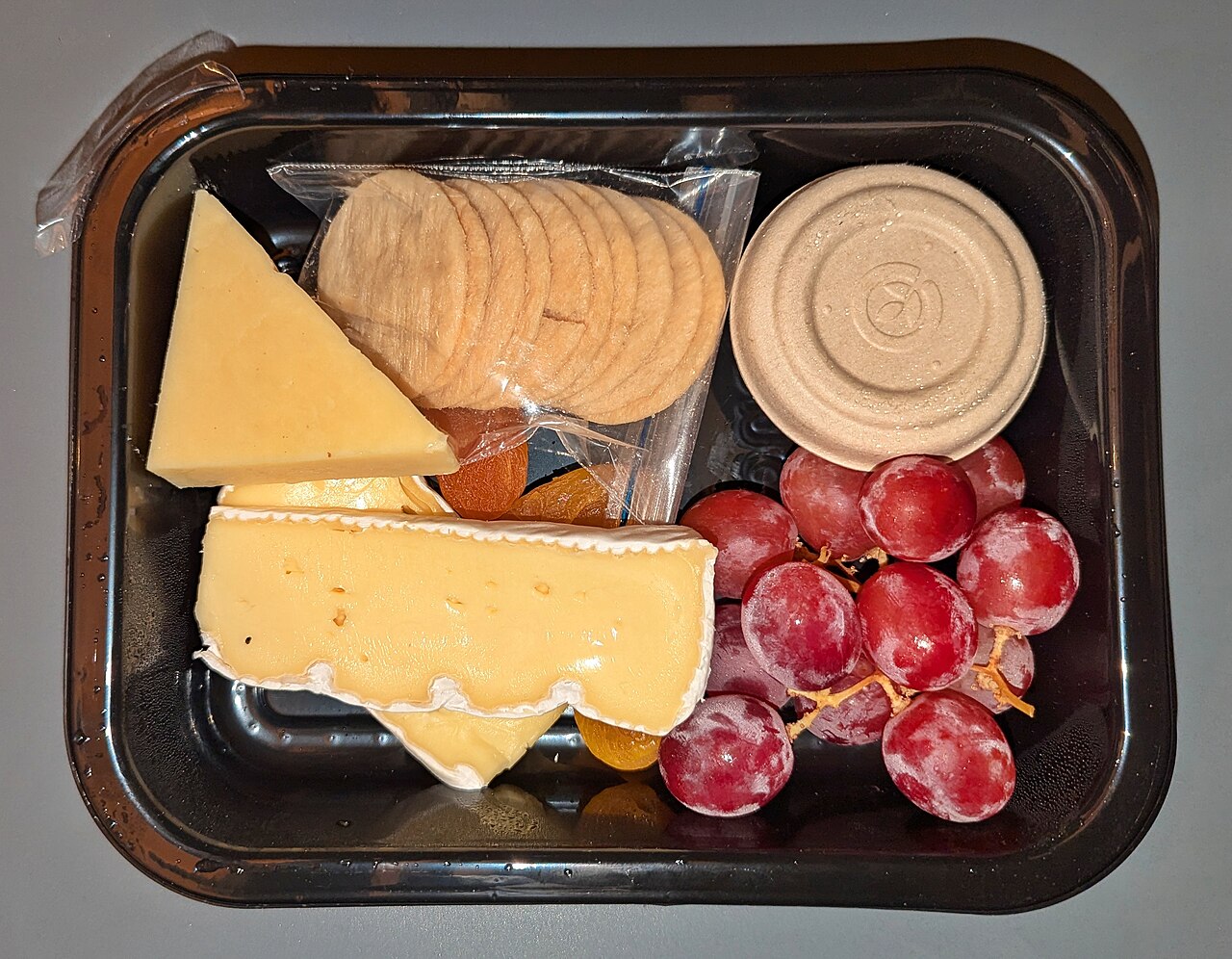 Cheese, crackers, grapes and dried fruit on a tray aboard Coastal Pacific