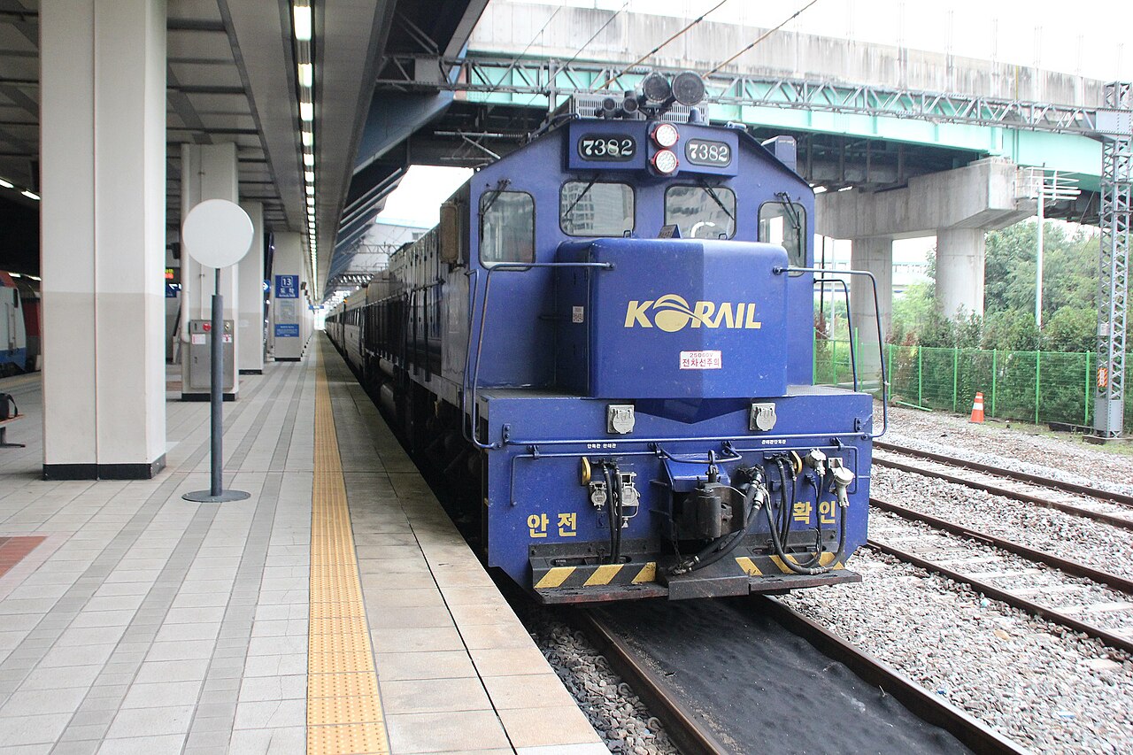 Blue Korail locomotive at the front of the Haerang train beside a station platform