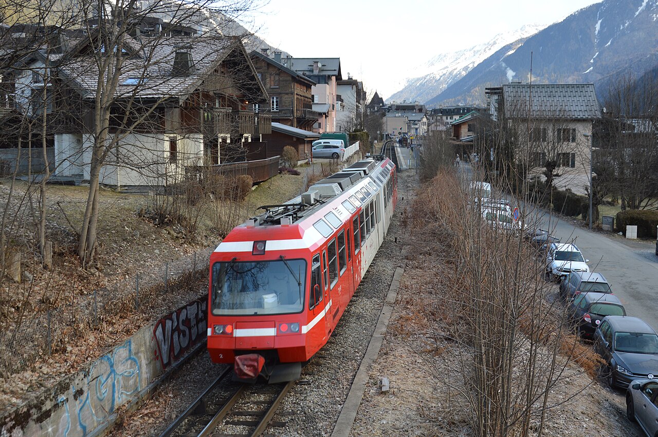 Red SNCF Z800 train between buildings in Chamonix on the French Mont Blanc route