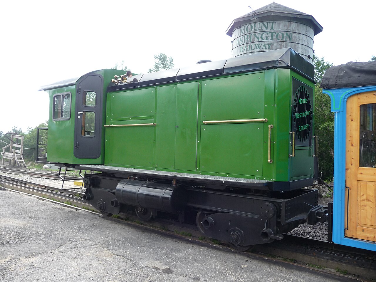 Green diesel cog locomotive and a yellow passenger carriage at Mount Washington Railway