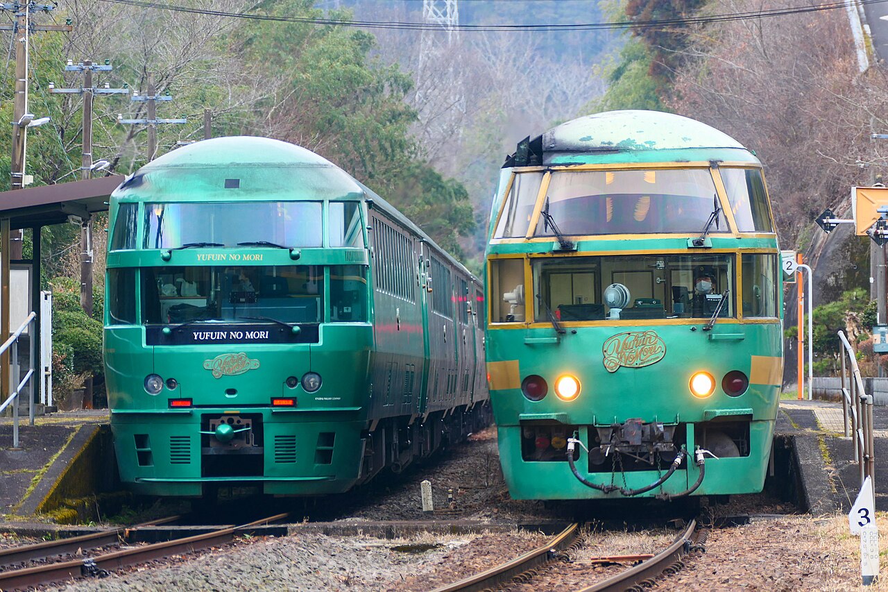 Two green Yufuin no Mori sightseeing trainsets side by side at Noya station